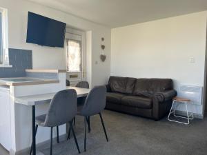 a living room with a couch and a table and chairs at Saltwater Chalet in Kessingland