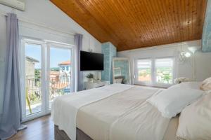 a bedroom with a large white bed and a balcony at Evan Seaview in Funtana +40 photos