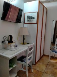 Habitación con escritorio con lámpara y TV. en Rodoflor Rooms, en Castellammare di Stabia