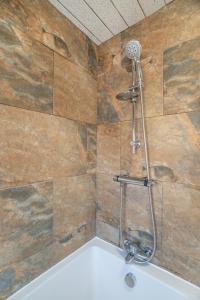 a shower in a bathroom with a stone wall at Cozy 3 Bed Apartment - Parking in Gateshead