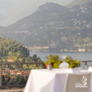 un tavolo con vista sul lago e sulle montagne di Hotel Il Perlo a Bellagio