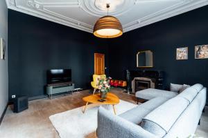 sala de estar con muebles azules y chimenea en Maison d'hôte Brasserie Caulier en Péruwelz