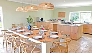 a kitchen with a large wooden table and chairs at Tiny Whale Lodge, a unique space for groups in Bensafrim