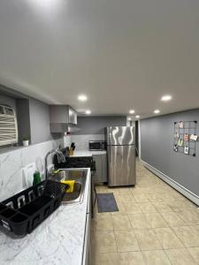 a kitchen with a sink and a refrigerator at 2 Bedroom Apartment By Airport in Hillside