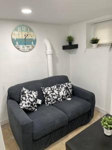 a blue couch in a living room with pillows on it at 2 Bedroom Apartment By Airport in Hillside