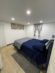 a bedroom with a blue bed in a room at 2 Bedroom Apartment By Airport in Hillside