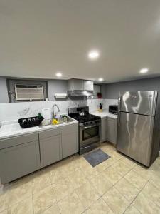 a kitchen with a stainless steel refrigerator and sink at 2 Bedroom Apartment By Airport in Hillside