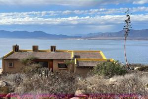 a house sitting on top of a hill next to the water at La casa del Mar en Guanaqueros! in Guanaqueros