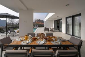 a wooden table with food on it on a patio at Villa Bella Ciao by SeeAdria Agency in Novigrad Istria