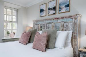 a bedroom with a large white bed with pillows at The Tranquil Auchterarder 3-bed Cottage in Auchterarder