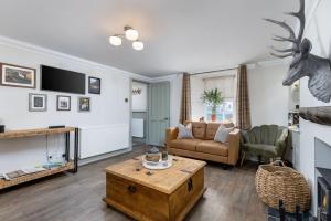 a living room with a couch and a table at The Tranquil Auchterarder 3-bed Cottage in Auchterarder