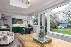 a kitchen with green cabinets and a table at The Tranquil Auchterarder 3-bed Cottage in Auchterarder