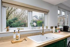 a kitchen counter with a sink and a window at The Tranquil Auchterarder 3-bed Cottage in Auchterarder +37 photos