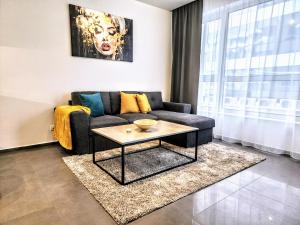 ein Wohnzimmer mit Sofa und Tisch in der Unterkunft Central Park Galleria in Burgas City