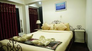 Rúm í herbergi á Cosy Hotel