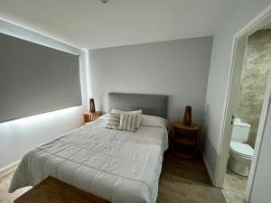 um quarto branco com uma cama e um WC em Departamento centrico vistas a la montaña em San Carlos de Bariloche