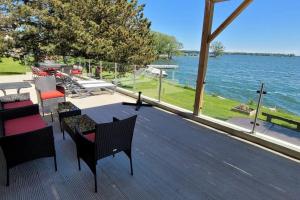 a deck with chairs and tables and a view of the water at SkyTime Vacations in Wellington
