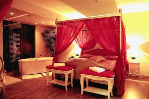 a bedroom with a canopy bed and a bath tub at Hotel Riz B.B in San Genesio ed Uniti