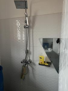 a shower in a white tiled bathroom at Beautiful 1-Bed Apartment in Gulu in Gulu