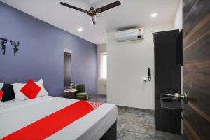 a bedroom with a bed and a ceiling fan at OYO Flagship IKON Stay and Restaurant in Hyderabad