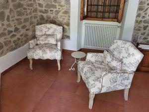 2 sillas y una silla y una mesa en una habitación en Chianti Villa Chicco, piscina privata, ampio giardino, BBQ e parcheggio, en Lucolena in Chianti