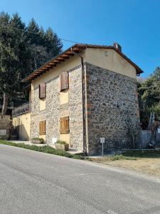 un antiguo edificio de piedra al lado de una carretera en Chianti Villa Chicco, piscina privata, ampio giardino, BBQ e parcheggio, en Lucolena in Chianti