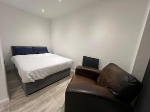 a bedroom with a bed and a couch and a chair at Cotes Yard in Loughborough