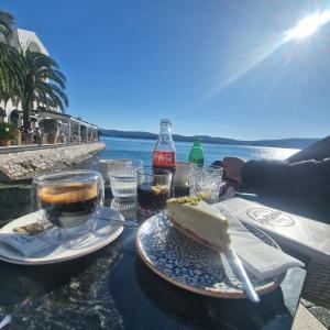 a table with a piece of cake and drinks on it at Apartmani Vila Marija in Budva