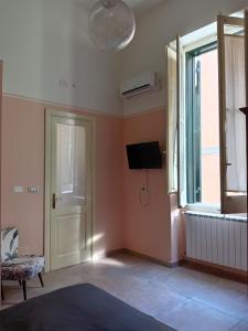 a room with a door and a tv and a window at Piazza Verdi Liberty House in Lecce