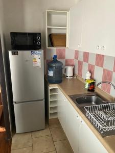 een kleine keuken met een koelkast en een wastafel bij Piso 5 Con estacionamiento - Sin Ascensor in Copiapó