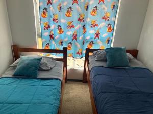 2 camas en una habitación con una pared y una ventana en Piso 5 Con estacionamiento - Sin Ascensor en Copiapó