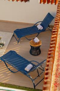 two blue chairs and a table on a patio at Casa Paraíso Lençóis in Santo Amaro