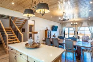 a living room with a table and chairs and a staircase at Lakefront Luxury Cottage - Shining Star - Close to Sauble Beach in Wiarton