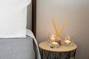 a table with candles and a table with a bed at Zefi's Aegina Apartment in Kapótidhes