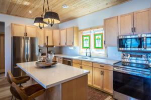a kitchen with wooden cabinets and a large counter top at Lakefront Luxury Cottage - Shining Star - Close to Sauble Beach in Wiarton