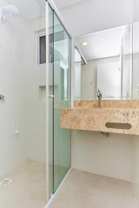 a bathroom with a sink and a shower at VC 106 - FLAT VILA DO CENTRO in Bombinhas