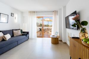 Una sala de estar con un sofá azul y una mesa. en Apartment in the heart of Fañabe area, en Adeje