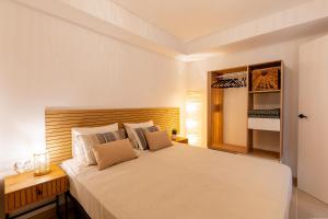 Un dormitorio con una cama grande con cabecero de madera. en Apartment in the heart of Fañabe area, en Adeje 21 fotos más