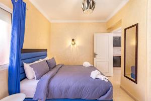 a bedroom with a bed with a blue canopy at Coin de verdure et détente. in Marrakesh
