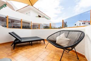 una silla y una mesa en el balcón de una casa en Apartment in the heart of Fañabe area, en Adeje