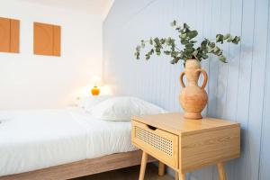 um vaso sentado numa mesa ao lado de uma cama em Double Studio au coeur des Marais Salants em Arles