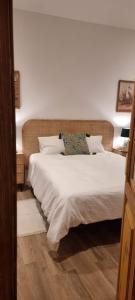 a bedroom with a bed with white sheets and a pillow at CasaDeVita in Tazacorte