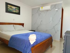 a bedroom with a bed with a blue blanket at Hotel Palma Real Cartagena in Cartagena de Indias