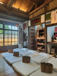 a room with a row of white beds in a room at Soho工房眷村生活體驗館 in Kaohsiung