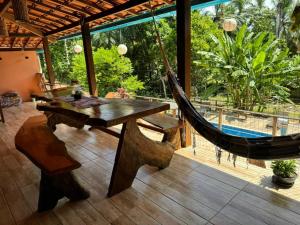a hammock on a patio with a pool at Casa Amadou com grande piscina em Boipeba in Ilha de Boipeba