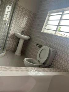 łazienka z toaletą i umywalką w obiekcie Joydora apartments 3 w mieście Lusaka