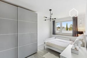 a white bedroom with a bed and a window at Apartment close to VF Tower - 53 SQM - Fair - Kitchen in Düsseldorf