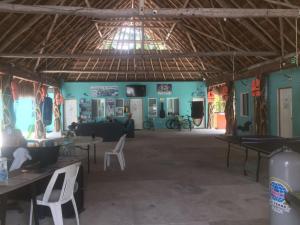 uma grande sala com mesas e cadeiras num edifício em Blue Magic Hostel em Cozumel