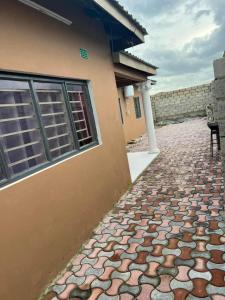 a house with a stone walkway next to a building at Joydora apartments 3 in Lusaka