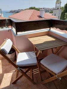 a picnic table and two chairs on a balcony at Guesthouse Olimp in Sozopol